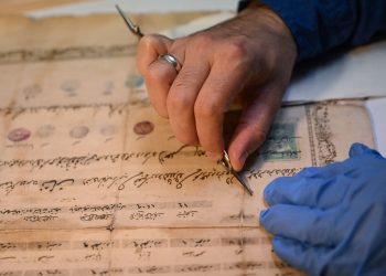 Atölyesinde eski evrak ve kitapları onarıp yeniliyor